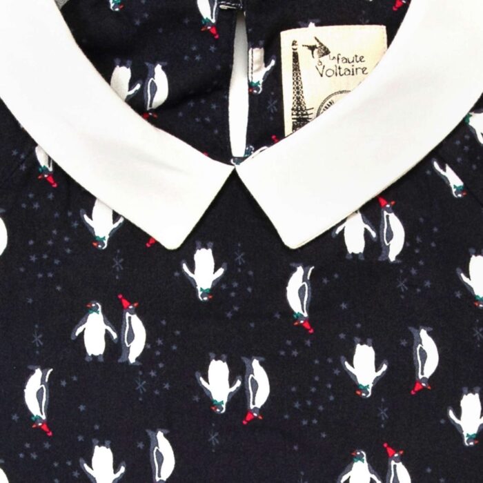 Fancy Christmas blouse for girl with long sleeves, black color with white and red penguin print, white Claudine collar. From the children's fashion brand LA FAUTE A VOLTAIRE