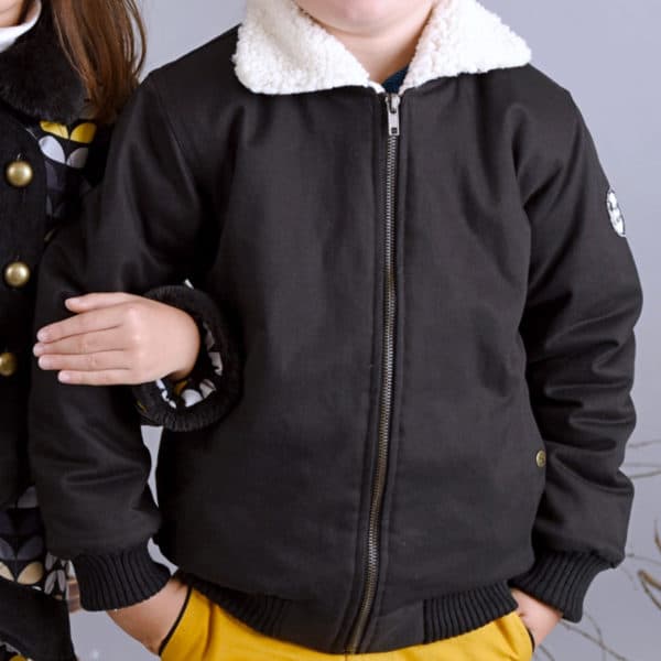 Offseason aviator jacket in black quilted cotton, with pockets, zippers and lining in beige faux fur imitation sheep for boys from 2 to 12 years old. La Faute à Voltaire, a French creative brand for children in fair trade.