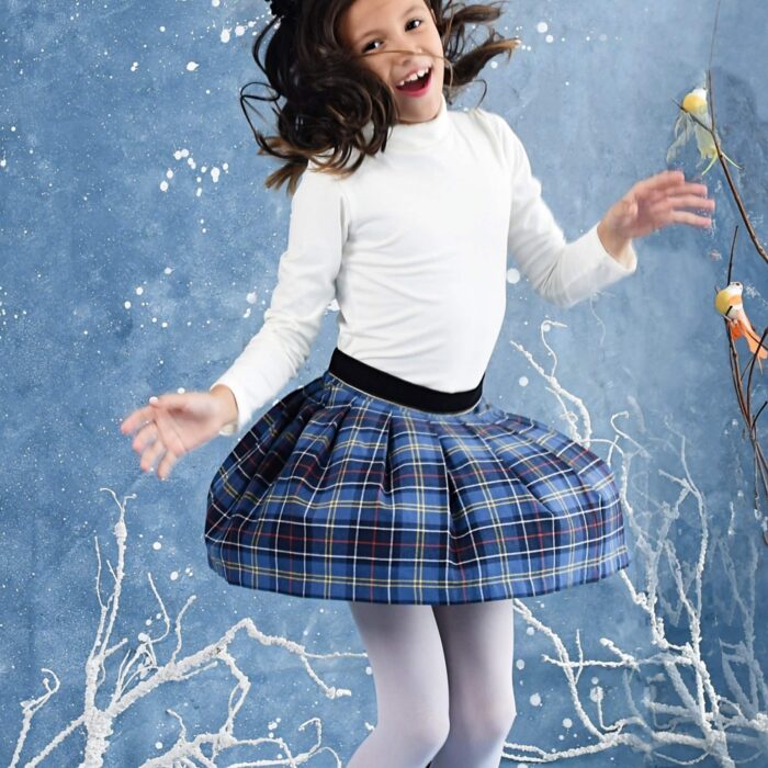 Pleated tartan skirt with royal blue tartan and yellow and red threads for little girls and teens from 2 to 14 years old. Black velvet belt and contrasting bias under the gold belt. Side opening with snap and zipper. French designer brand LA FAUTE A VOLTAIRE
