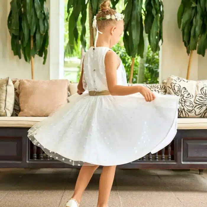 Robe de cérémonie qui tourne pour fille en tulle blanc cassé. et ceinture en lin doré, emmanchures américaines bordé de biais or. Robe de cortège et mariage pour filles, fillettes et ados de la marque de mode pour enfant LA FAUTE A VOLTAIRE