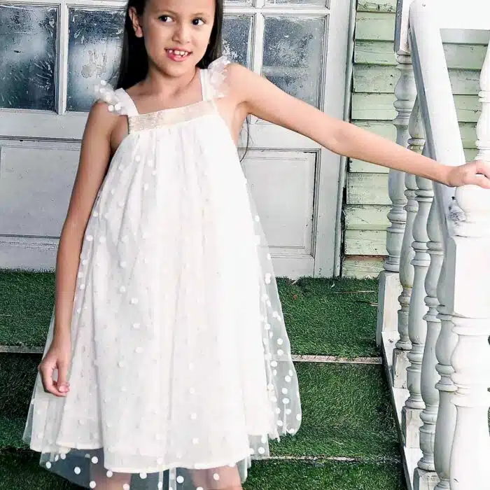 Une Magnifique Robe de cérémonie bohème Chic en voile Beige avec col carré à paillettes dorées, bretelles à volants, doublure en coton. Modèle Alizée de la marque de mode Française pour enfants LA FAUTE A VOLTAIRE