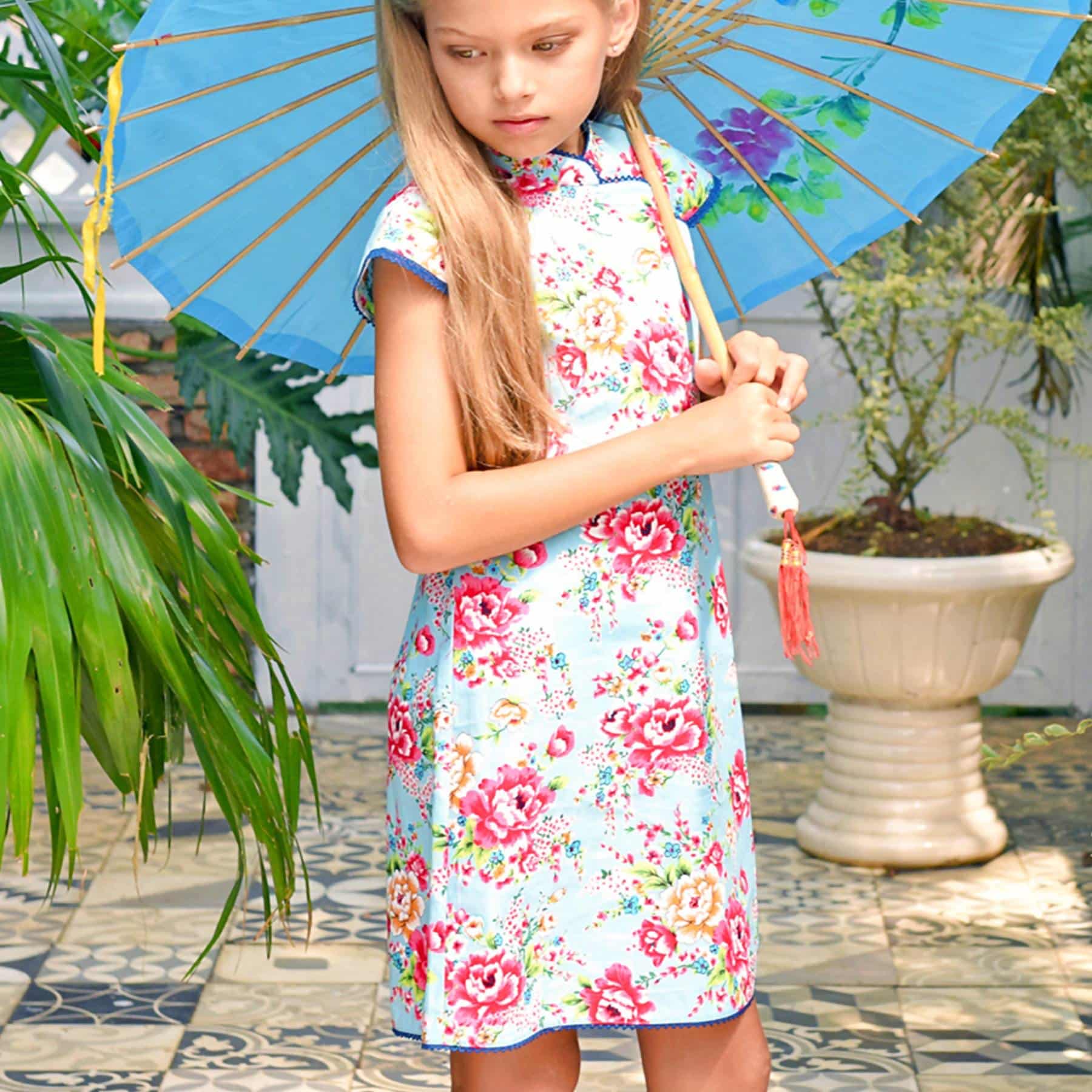 Turquoise blue Chinese dress with fuchsia pink Asian flowers, Mao collar trimmed with fine navy blue lace from the children's fashion brand LA FAUTE A VOLTAIRE