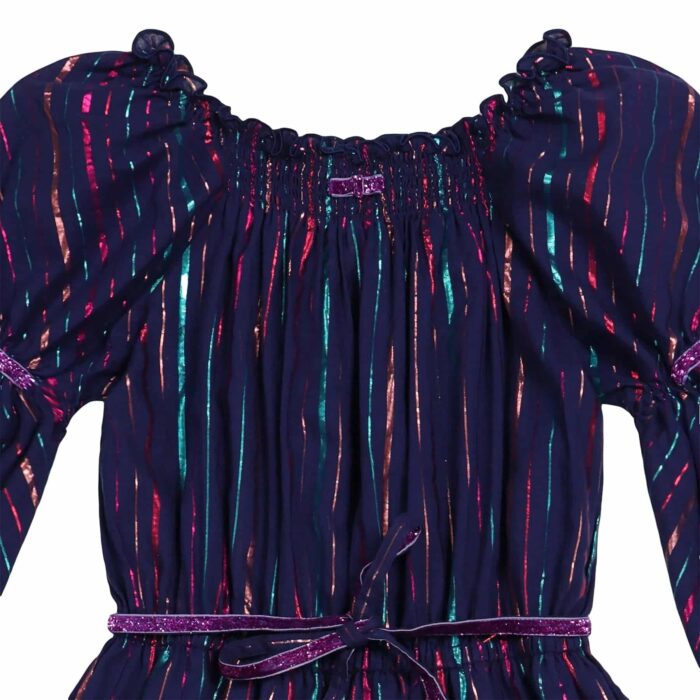 Long evening dress for little girls in indigo blue cotton with fine stripes multicolored sequins pink, green, purple. Smocked collar and long puffed sleeves with elastic cuffs. Ruffles at the bottom of the dress. Purple sequin ribbon details at the bottom of the dress. Purple belt with removable sequins, elastic waist. Fashion brand for children LA FAUTE A VOLTAIRE