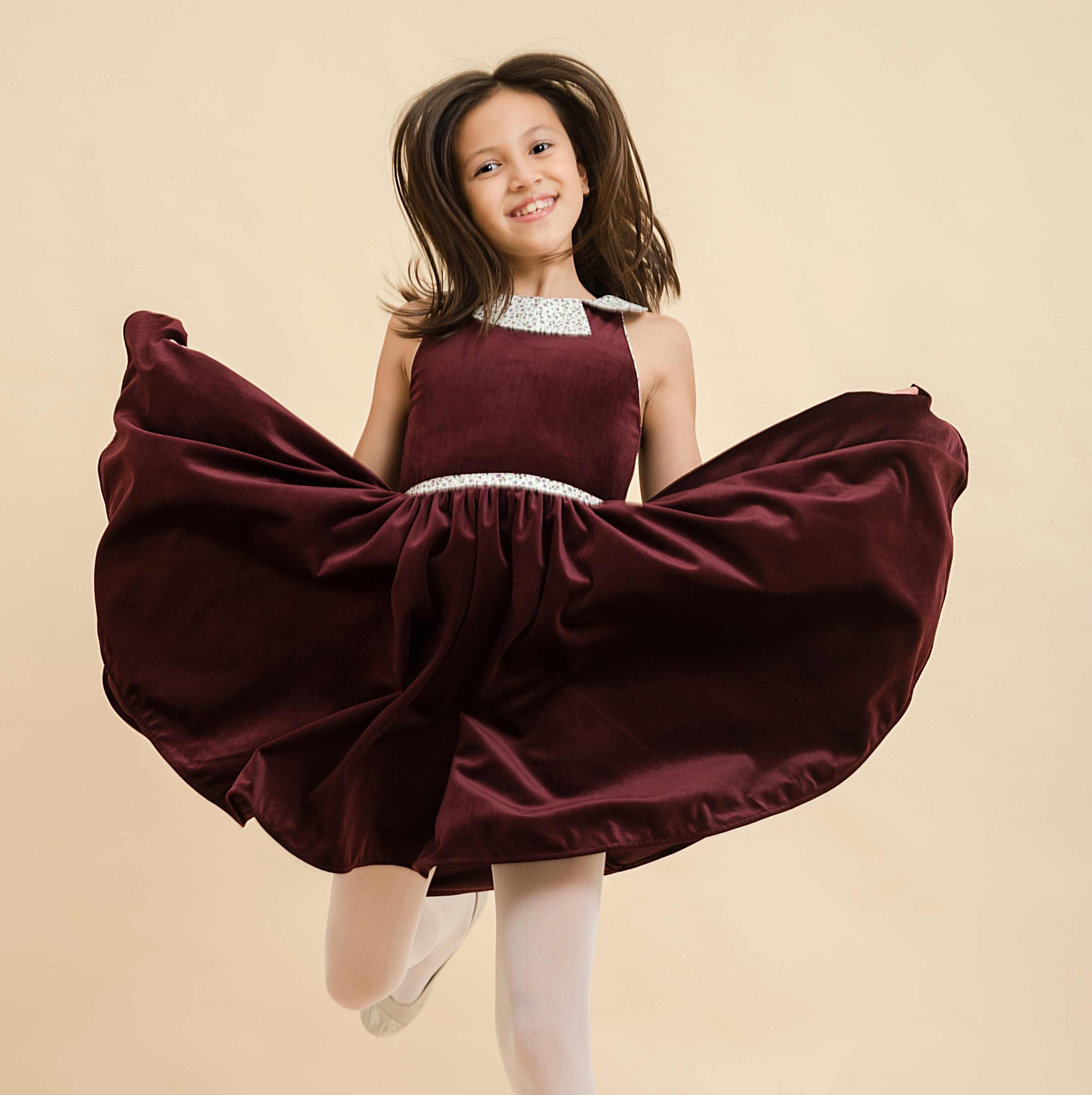 On Craque pour cette Magnifique Robe qui Tourne en Velours Millerais Couleur Bordeaux Prune pour Fille et Fillette de 2 à 16 ans. La Robe Patineuse Hepburn est une Robe Classique Chic qui Tourne à l'Horizontal. Avec son Col Claudine Fleuri Liberty à Petites Fleurs Violettes et sa Ceinture Intégrée Assortie, cette robe est Parfaite pour Tous l es grands Évènements de l'Automne et Hiver comme la Rentrée Scolaire, Noël ou les Mariages d'Automne ou Anniversaire en Famille. La Faute à Voltaire est une Marque de Vêtements Enfants Française Produite en Commerce Équitable depuis 2009.