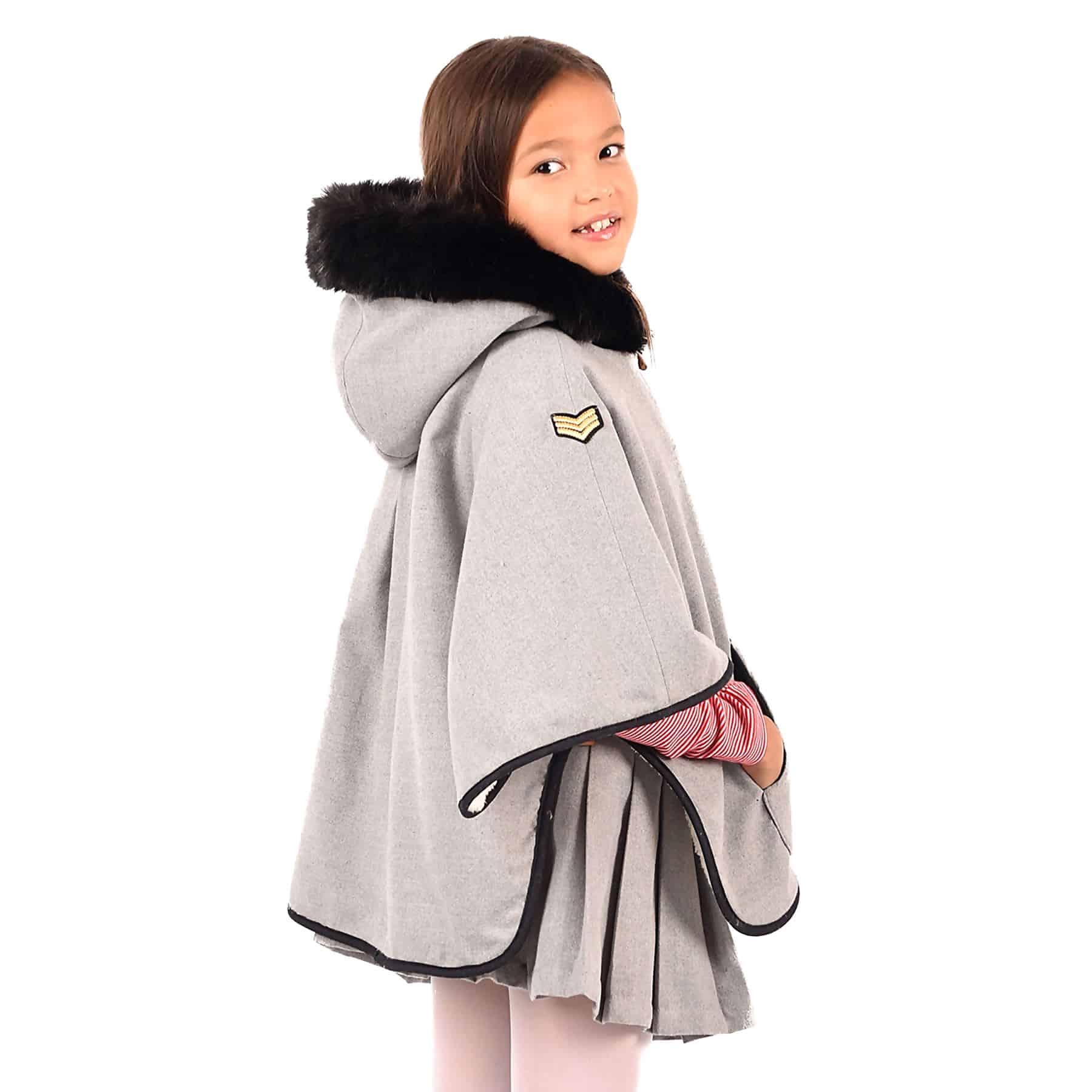 Grey wool coat with large white faux fur hood and white faux fur pockets from children's fashion brand LA FAUTE A VOLTAIRE