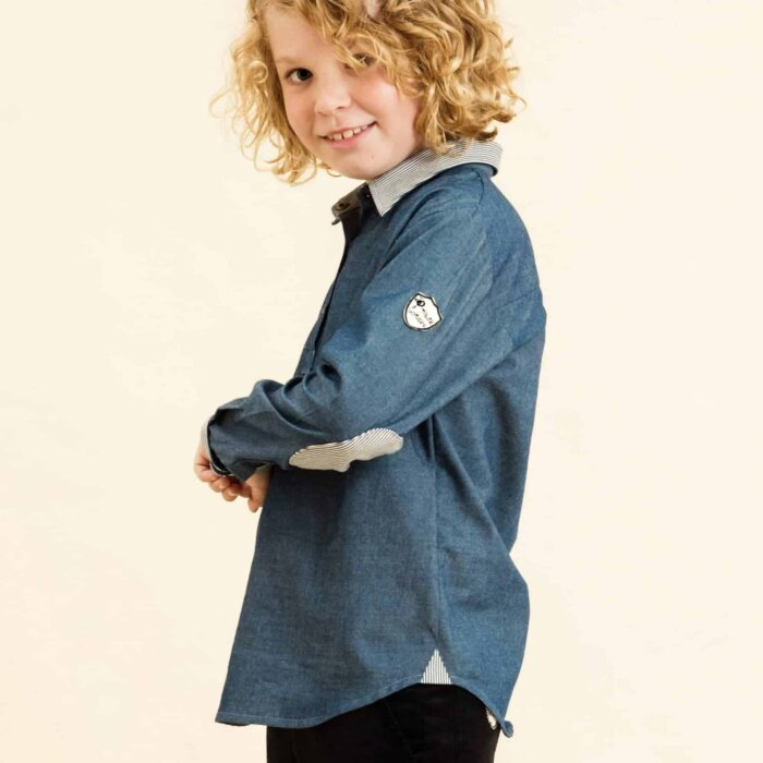 Belle chemise bleu denim avec découpe de jean rayé au col et coudières, fermeture avec bouton pression pour garçons de la marque de mode pour enfants La Faute à Voltaire