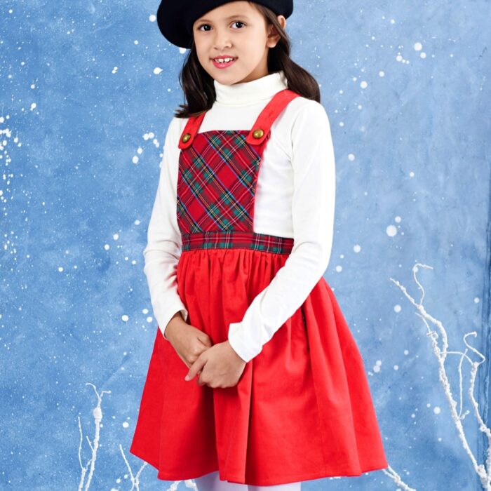 Une Adorable Robe de Noël pour Fille façon Salopette avec Bretelles Ajustables. Très Originale en Velours Rouge en Bas et Plastron Avant en Carreaux Tartan Rouge et Vert. Très Confortable avec Taille Élastique. Modèle Spécial Fêtes de Noël pour Enfant de la Marque de Mode pour Enfant La Faute à Voltaire.