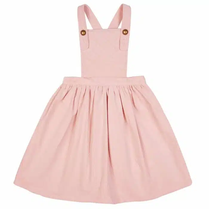 Cet Hiver, Offrez cette Magnifique Rose Salopette façon Tablier en Velours Rose Pastel, Bretelles Croisées dans le dos, Gros Bouton Rond Couleur Bronze sur le devant, Poches bordées de Biais Dorés sur les Côtés de la marque de Mode Française pour Enfants La Faute à Voltaire.