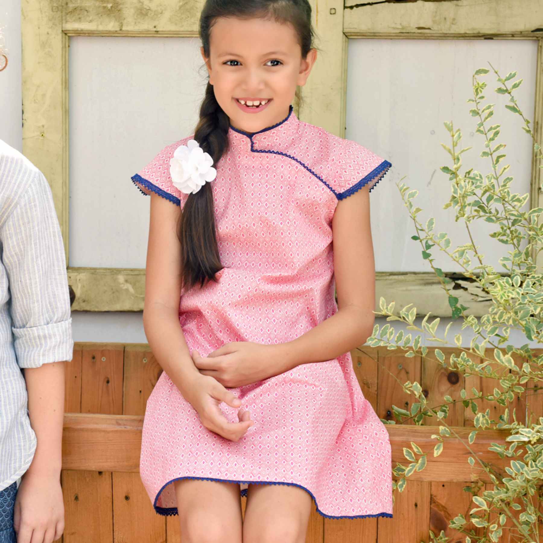 Elegant Chinese dress in pink fuchsia cotton diamond print. and white, Mao collar trimmed with fine navy blue English lace, short bias sleeves from the children's fashion brand LA FAUTE A VOLTAIRE