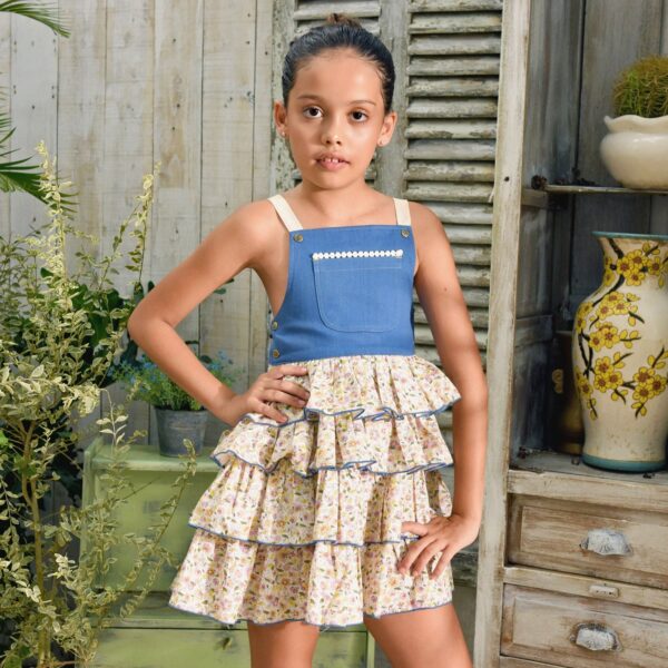 Summer overalls dress for girls in blue denim cotton on the front breastplate and ruffles on the liberty flower skirt pale yellow, lilac, light pink. Cross straps in the back adjustable and pocket on the front. Dress of the fashion brand for children and teenagers LA FAUTE A VOLTAIRE
