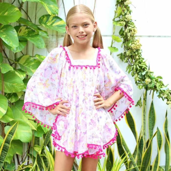 Loose white beach tunic with pink butterfly print and square neckline trimmed with white lace and fuchsia pink pompon