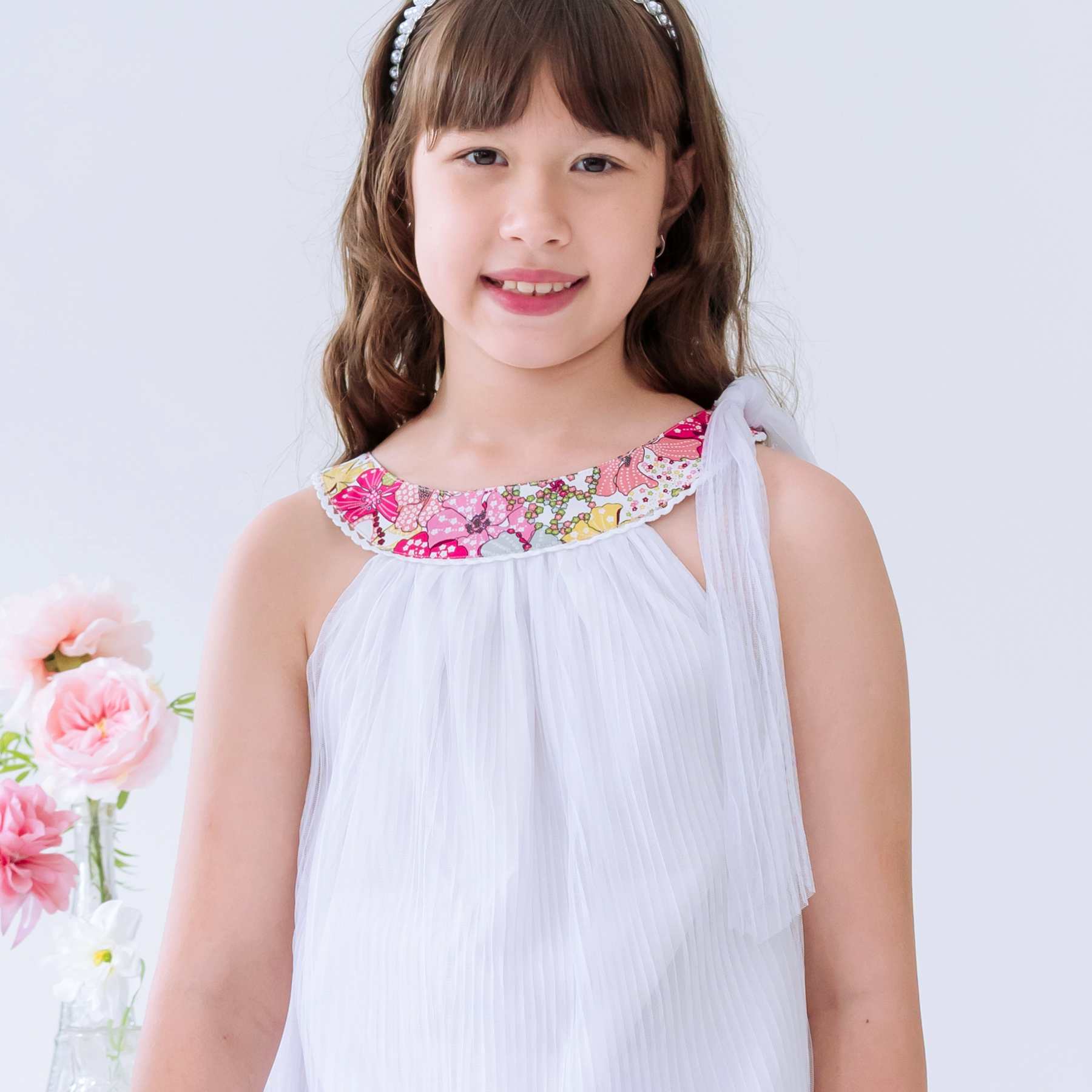 Photo portée gros plan de la Robe cérémonie bohème blanche fille col liberty rose Alizée.