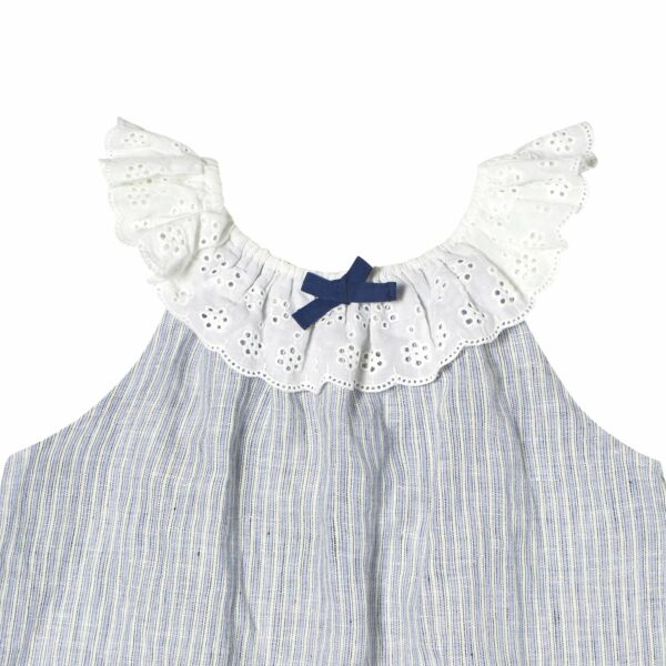 Bohemian summer blouse for girls with thin light blue and white stripes, elastic collar in white broderie anglaise, sleeveless, decorative navy blue bow on the collar. French children's fashion brand LA FAUTE A VOLTAIRE