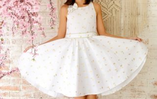 Dress which turns of ceremony in white linen and printed golden coconuts for small from 2 to 14 years of the fashion brand for children LA FAUTE A VOLTAIRE