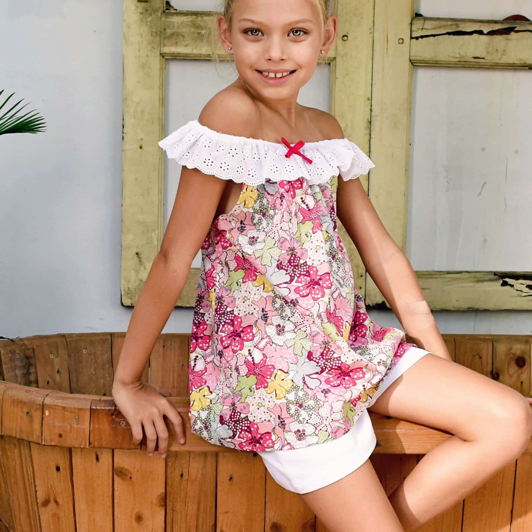 Red pink floral blouse with elastic collar in white embroidery anglaise from the fashion brand. for children LA FAUTE A VOLTAIRE