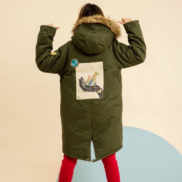 long and warm parka for teenager girl and woman in khaki cotton lined fake fur beige sheep, hood lined with faux fur imitation fox, vintage poster for the protection of animals in the back of the fair trade fashion brand THE FAULT TO VOLTAIRE