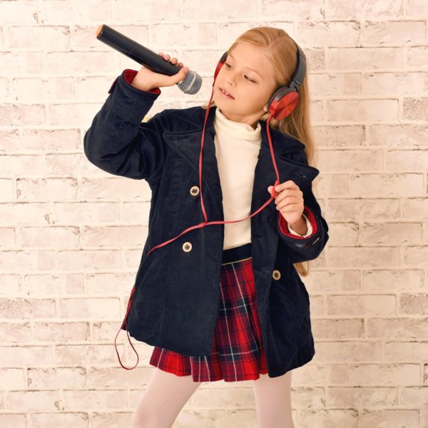 Scottish skirt in woolen red tartan tiles for girls and teenagers from 2 to 16 years old, with integrated belt in black velvet and contrasting golden bias. Side closure with snap and zipper. French brand creator of LA FAUTE A VOLTAIRE