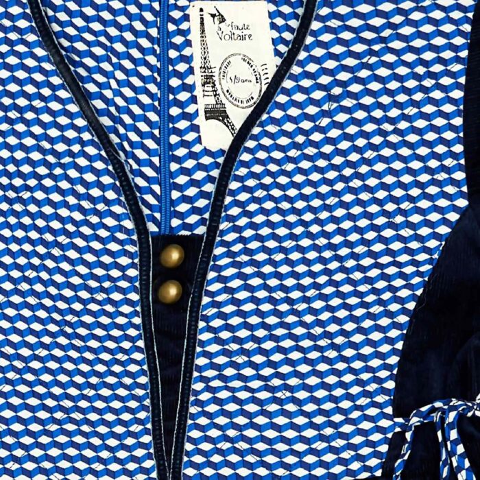 Une Magnifique Robe d'Hiver Bleu Marine d'inspiration Médiéval avec Plastron en Coton Matelassé Imprimé Bleu Roi et Blanc, Manches Longues, Col V bordé de Ruban Bleu Marine de la Marque de Mode Française pour Enfant La Faute à Voltaire.