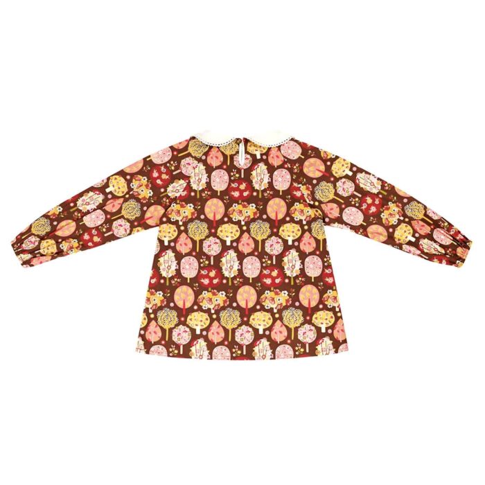 little girl's blouse in brown cotton with pink, yellow and green tree print. With white Claudine collar edged with white lace, small rounded pockets on the front. Blouse model Claudine of the brand LA FAUTE A VOLTAIRE