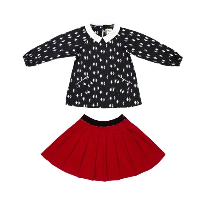 Tenue de Noël pour filles de 2 à 12 ans composée d'une blouse noir col Claudine blanc à l' imprimé fantaisie de pingouins avec bonne de Noël rouge et d'une jupe plissée en velours rouge de la marque créateur française LA FAUTE A VOLTAIRE.