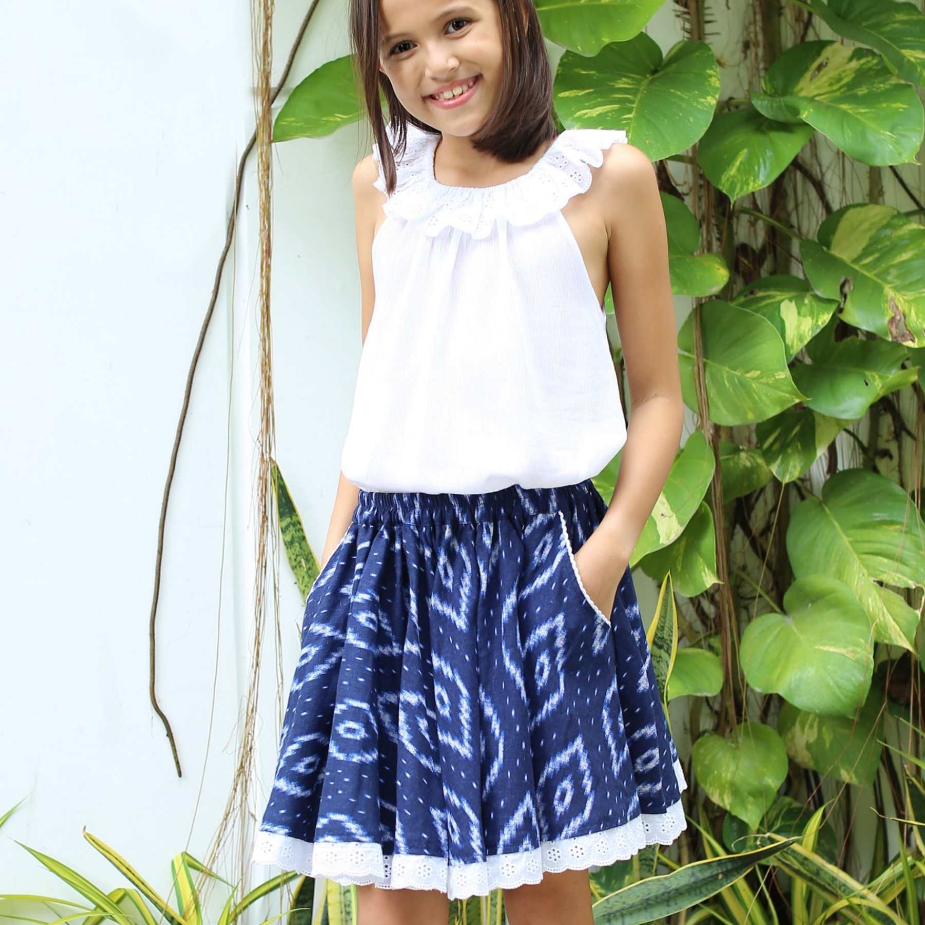 Photo portée de la jupe qui tourne bleu marine fille avec broderie anglaise et dentelle blanche. Tailles disponible du 2 au 16 ans.