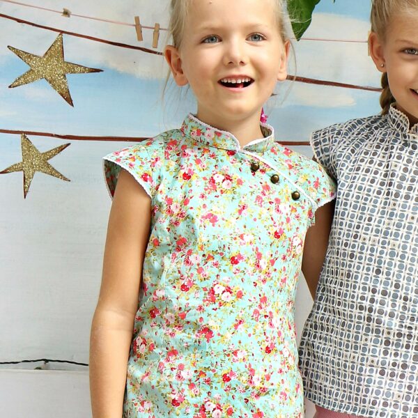 Chinese girl dress with Mao collar in water green liberty cotton with red flowers, round bronze buttons diagonally on the chest, white lace on the collar and short sleeves. Fashion brand for children and teenagers from 2 to 16 years old LA FAUTE A VOLTAIRE