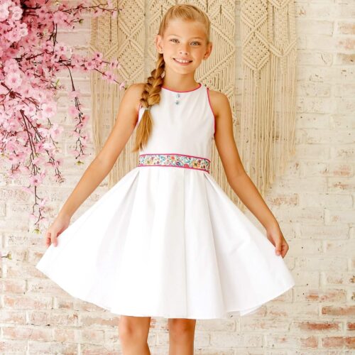 Robe de Demoiselle d'Honneur, Robe de Communion, Robe de cortège Blanche pour filles et fillettes avec ceinture en tissu fleuri liberty rose, nœud dans le dos, sans manches avec emmanchures américaine. Robe qui Tourne Hepburn de la marque de mode pour enfant LA FAUTE A VOLTAIRE