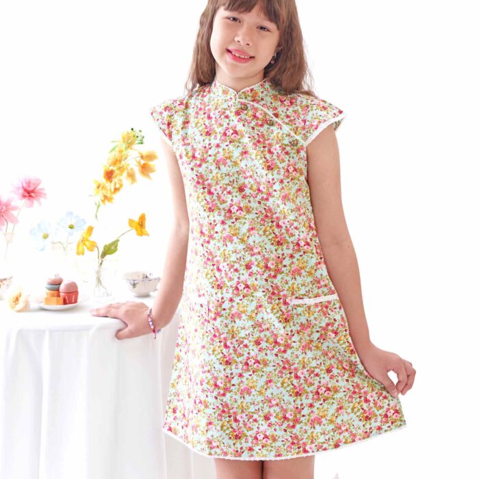 On Craque pour cette Magnifique Robe Chinoise en Coton Fleuri Liberty Vert d'au et Rouge. A manches Courtes Coupé en Biais selon la Tradition Asiatique. Un Joli Col Mao Bordé de Fine Dentelle Anglaise Beige et Petites Poches Décoratives sur le Devant. Robe d'Été Disponible du 2 au 16 ans Créée par la Marque de Mode Française pour enfants en Commerce Équitable La Faute à Voltaire.
