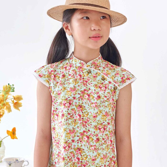 On Craque pour cette Magnifique Robe Chinoise en Coton Fleuri Liberty Vert d'au et Rouge. A manches Courtes Coupé en Biais selon la Tradition Asiatique. Un Joli Col Mao Bordé de Fine Dentelle Anglaise Beige et Petites Poches Décoratives sur le Devant. Robe d'Été Disponible du 2 au 16 ans Créée par la Marque de Mode Française pour enfants en Commerce Équitable La Faute à Voltaire.