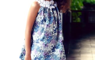 Jolie robe d'été en coton fleuri liberty bleu, violet et lilas avec col élastique à froufrous blanc. Modèle robe été de la marque de mode pour enfant LA FAUTE A VOLTAIRE