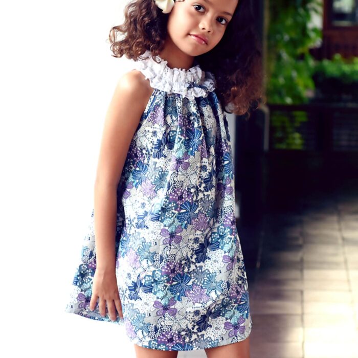 Pretty summer dress in blue, purple and lilac liberty floral cotton with white frilly elastic collar. Summer dress model of the fashion brand for children LA FAUTE A VOLTAIRE