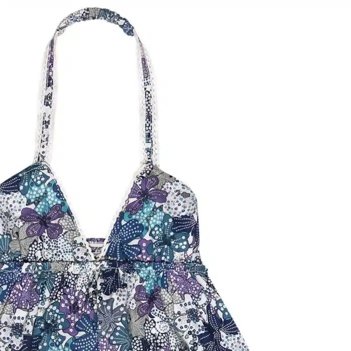 Robe longue été fille en coton fleuri liberty bleu, violet et lilas, col V bordé de dentelle blanche, bretelles tourr du cou, volants en bas de la robe. Modèle Eugénie de la marque de mode pour enfants la faute a voltaire