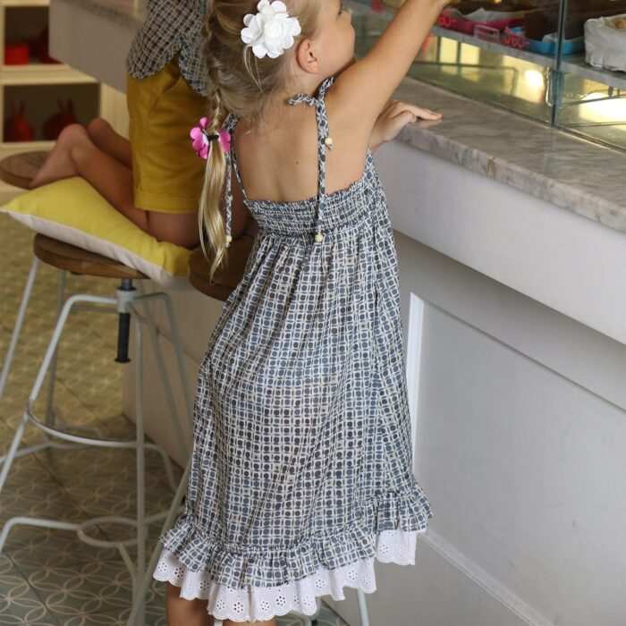 Jolie robe qui tourne en coton imprimé bleu et beige, avec des fines bretelles, de la dentelle blanche et des volants. Robe de la marque de mode pour enfants et ados LA FAUTE A VOLTAIRE.