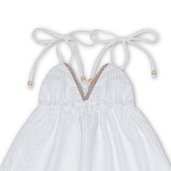 Pretty dress that turns in white cotton, with thin straps, beige lace and ruffles. Dress of the fashion brand for children and teenagers LA FAUTE A VOLTAIRE.