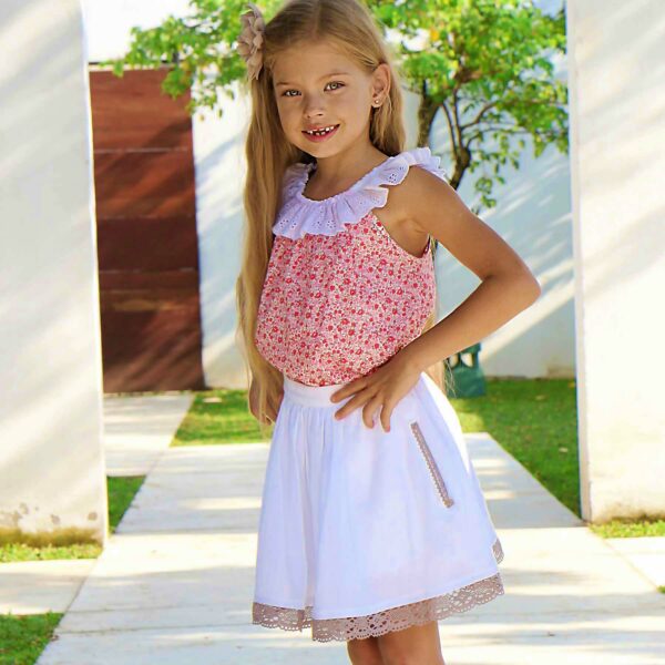Pretty sleeveless blouse cotton liberty flowered light pink and dark pink with an extendable collar in white English embroidery. Aurore blouse model from the fashion brand. for children and teenagers LA FAUTE A VOLTAIRE