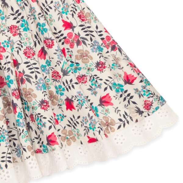 Pretty summer skirt in red and blue flowered cotton, with white embroidery anglaise for girl. Skirt of the fashion brand for children and teenagers LA FAUTE A VOLTAIRE.