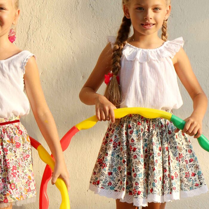Pretty summer skirt in red and blue flowered cotton, with white embroidery anglaise for girl. Skirt of the fashion brand for children and teenagers LA FAUTE A VOLTAIRE.