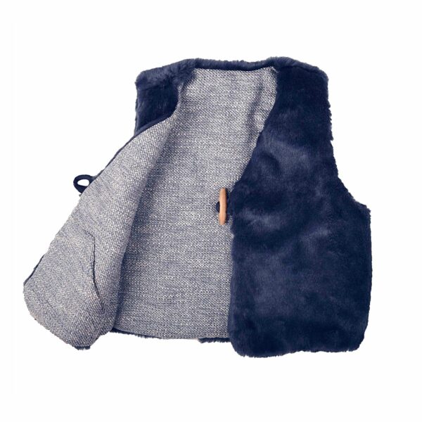 Nice sleeveless shepherd's vest for girl in navy blue, in very soft fake fur, and a closure with a nice wooden button. Vest lined in tweed material and reversible to wear it in two different ways. Model PETITE BERGERE of the fashion brand for children and teenagers LA FAUTE A VOLTAIRE.