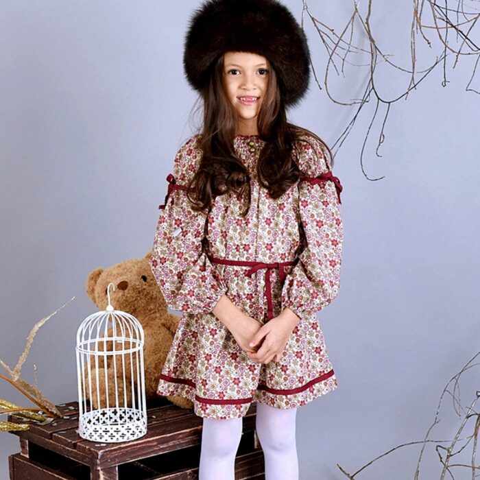 Pretty burgundy cotton flowered dress for girls. The dress can be worn several years in a row because it turns into a tunic. With its balloon sleeves, its smocked collar and its two pretty round bronze buttons, this tunic dress is very trendy. Dress model CHIMENE of the fashion brand for children and teenagers LA FAUTE A VOLTAIRE.