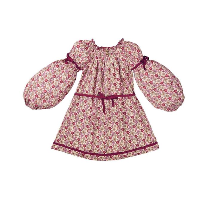 Pretty burgundy cotton flowered dress for girls. The dress can be worn several years in a row because it turns into a tunic. With its balloon sleeves, its smocked collar and its two pretty round bronze buttons, this tunic dress is very trendy. Dress model CHIMENE of the fashion brand for children and teenagers LA FAUTE A VOLTAIRE.