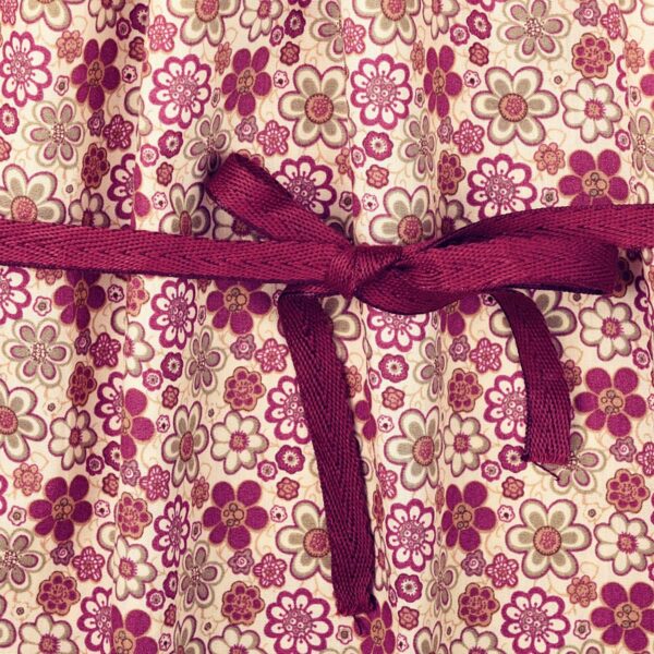 Pretty burgundy cotton flowered dress for girls. The dress can be worn several years in a row because it turns into a tunic. With its balloon sleeves, its smocked collar and its two pretty round bronze buttons, this tunic dress is very trendy. Dress model CHIMENE of the fashion brand for children and teenagers LA FAUTE A VOLTAIRE.