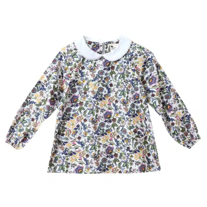 Jolie blouse pour filles et ados de 2 à 16 ans en coton fleuri liberty rose et multicolore, à col Claudine blanc bordé de fine dentelle anglaise blanche, à manches longues ajustables et élastiques aux poignets. Modèle Claudine de la marque de mode pour enfant LA FAUTE A VOLTAIRE