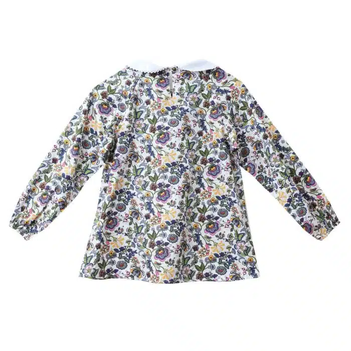 Jolie blouse pour filles et ados de 2 à 16 ans en coton fleuri liberty rose et multicolore, à col Claudine blanc bordé de fine dentelle anglaise blanche, à manches longues ajustables et élastiques aux poignets. Modèle Claudine de la marque de mode pour enfant LA FAUTE A VOLTAIRE
