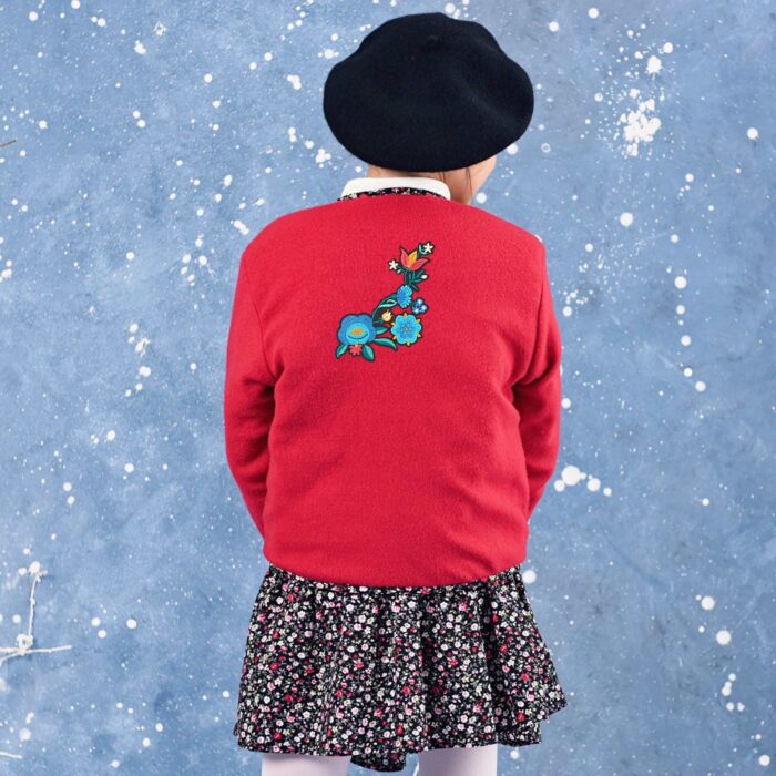 Pretty long sleeve jacket in red fleece lined with black and pink floral cotton with multicolored flower patch on the back. Short jacket for girls from the children's fashion brand LA FAUTE A VOLTAIRE