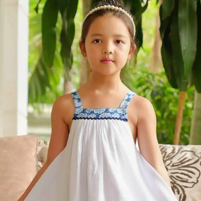 Très jolie robe de cortège ample et à bretelles pour filles et ado en coton crêpe blanc et col carré doublé de coton fleuri bleu roi, de la marque de mode pour enfant LA FAUTE A VOLTAIRE