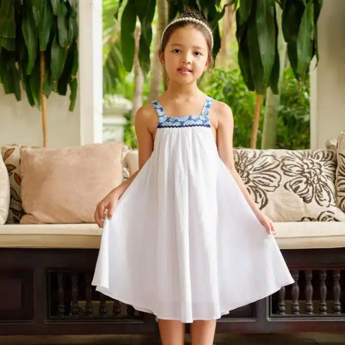 Très jolie robe de cérémonie blanche ample et à bretelles pour demoiselle d'honneur et fille en coton crêpe blanc et col carré doublé de coton fleuri bleu roi, de la marque de mode pour enfant LA FAUTE A VOLTAIRE