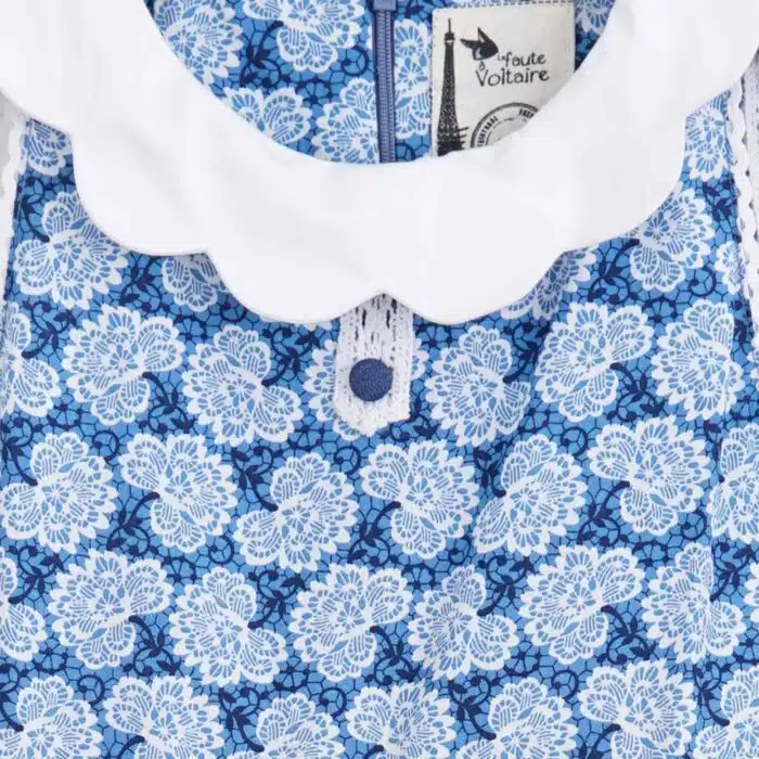 Magnifique robe qui tourne en fin coton denim en bas et beau coton fleuri bleu roi et blanc en haut, avec col blanc forme pétale, ceinture en dentelle blanche, sans manche. Modèle HEPBURN pour filles et ados de 2 à 16 ans de la marque de mode LA FAUTE A VOLTAIRE