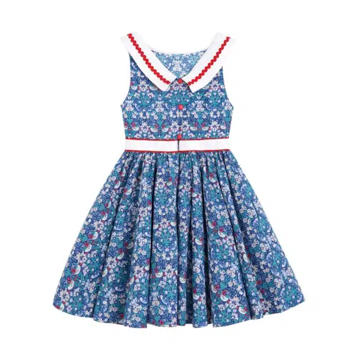 Elégante robe qui tourne à l'horizontal à l'imprimé floral et oiseaux bleu marine, vert et rouge, large col bateau blanc avec dentelle en zigzag rouge, ceinture blanche, emmanchure américaine pour filles de 2 à16 ans de la marque de mode pour enfants LA FAUTE A VOLTAIRE