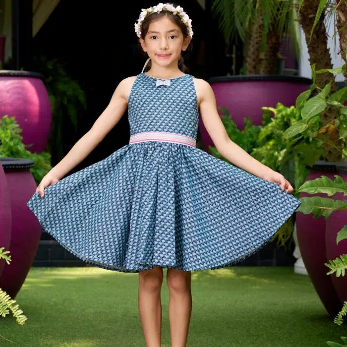 robe qui tourne bleu marine avec ceinture et noeud à paillettes. Modèle sans manche imprimé arbres bleu clair de la marque de mode pour enfant La Faute à Voltaire