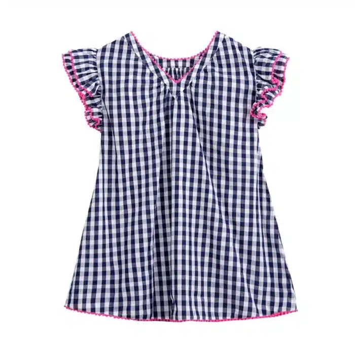 Jolie robe à carreaux vichy bleu marine et blanc, à manches papillons à volants, col rond devant et col V dans la nuque, rangée de pompons rose fuchsia autour des volants, col et bas de la robe. Robe été pour filles, fillettes et ados de la marque de mode pour enfants La Faute à Voltaire